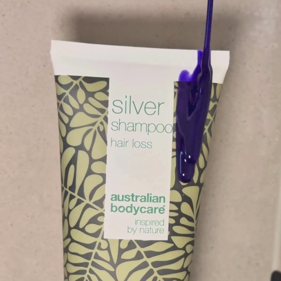 Video, jossa näkyy hopeanvioletti Hair Loss Silver Shampoo levitettävän märkiin hiuksiin suihkussa.
