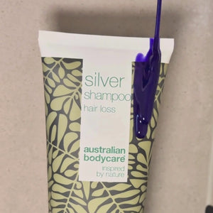 Video, jossa näkyy hopeanvioletti Hair Loss Silver Shampoo levitettävän märkiin hiuksiin suihkussa.