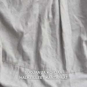 Lähikuva kädestä, joka ottaa rikasta, kermaista Heel Repair -voidetta kämmenelle ja hieroo sitä varovasti kuivalle, halkeilevalle kantapään iholle: paksu koostumus imeytyy näkyvästi, pehmentää ja kosteuttaa karkeaa ihoa, samalla kun 25 % urea, sheavoi ja tea tree -öljy rauhoittavat ja suojaavat ihoa.